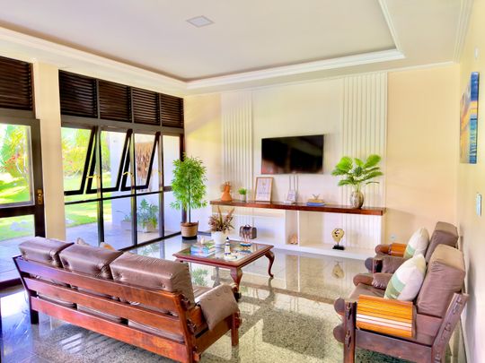 Sala de estar com sofás de couro, TV 50” e decoração completa